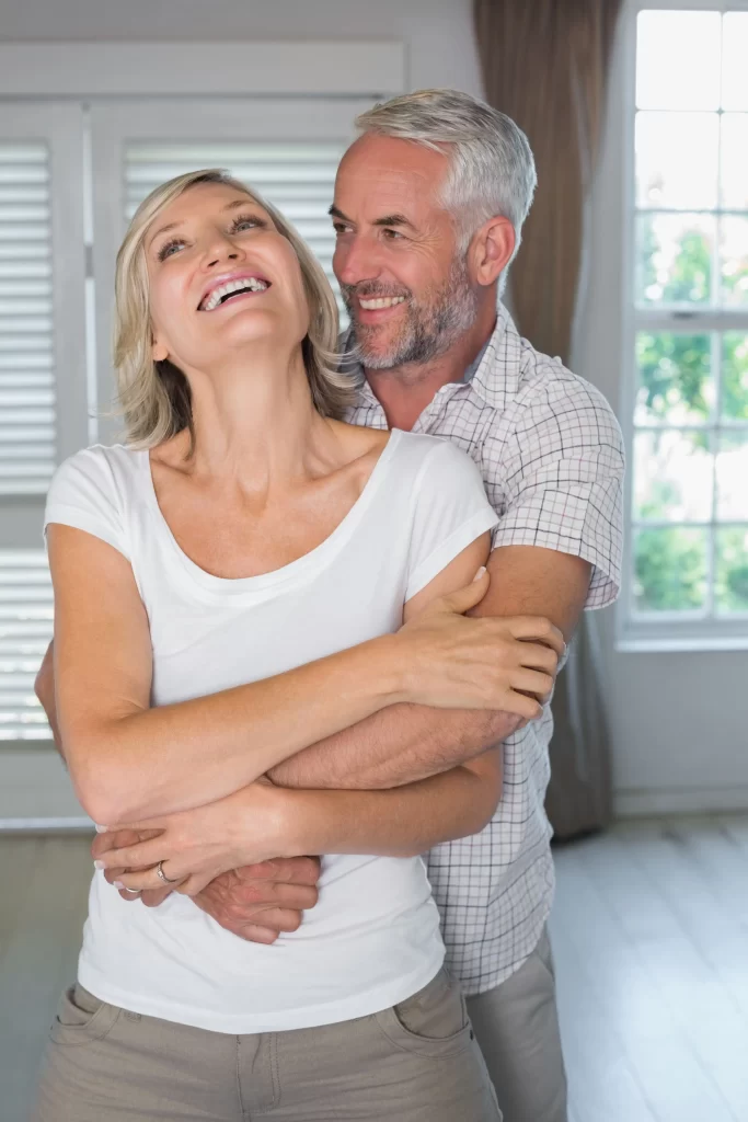 mature man embracing woman from min